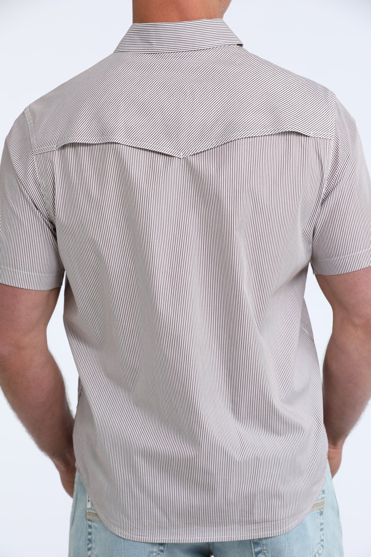 Man wearing a gray short-sleeve button-up shirt with a subtle pattern on a white background