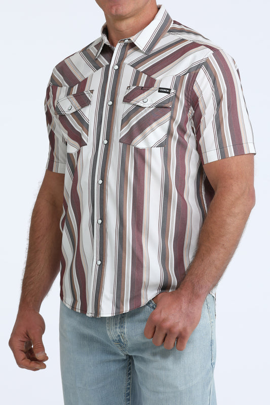 Man wearing a striped short-sleeve shirt with a neutral background