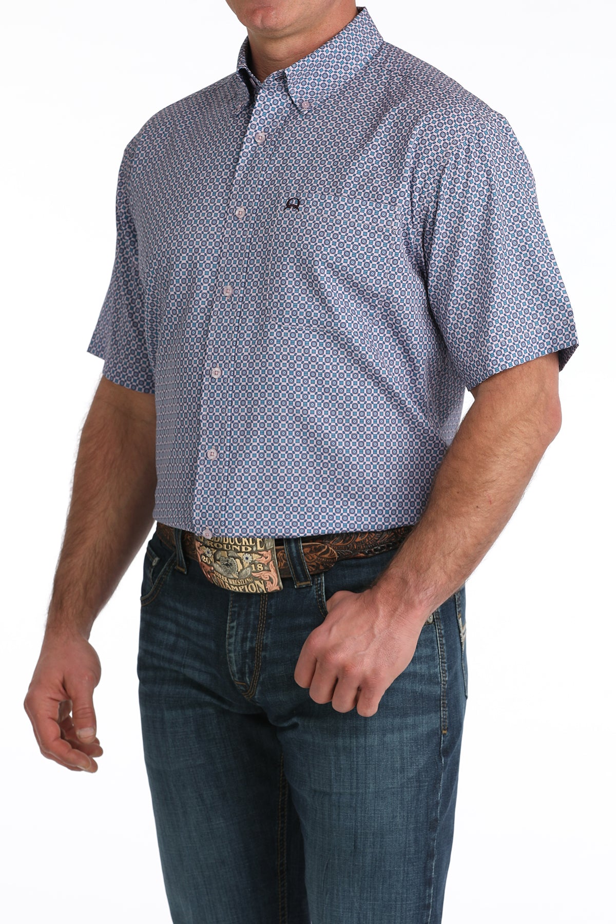 Man wearing a patterned short-sleeve shirt and jeans on a white background