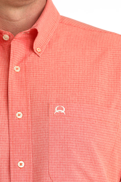 Close-up of a red checkered shirt with a small logo on a white background