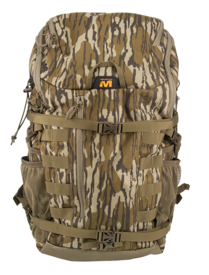 A large tactical backpack in a woodland camouflage pattern with brown, tan, and gray tones, featuring multiple compression straps, side mesh pockets, and a black and orange logo patch on the front.