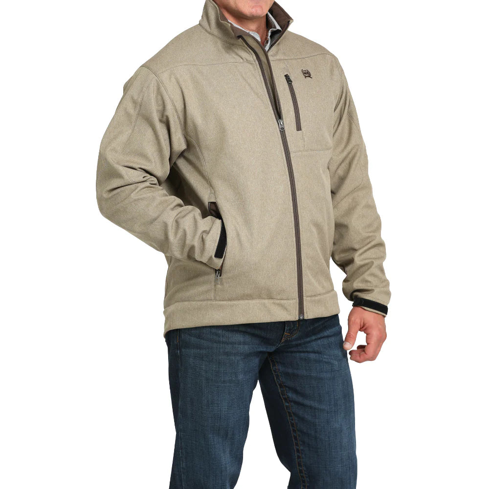 Men's beige softshell jacket with zip pockets, standing collar, and blue jeans