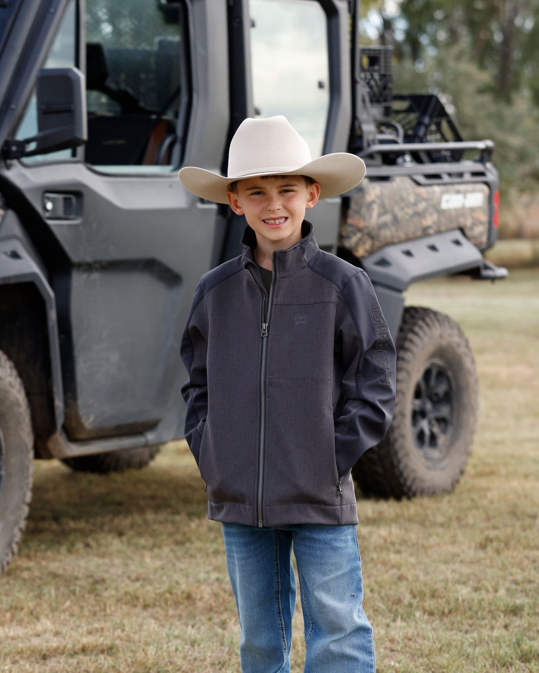 BOY WITH GREY JACKET OUTDOORS