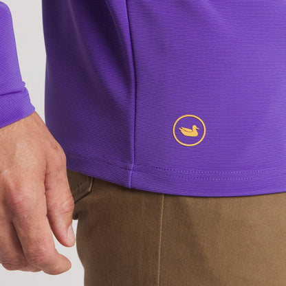 Purple textured shirt with yellow duck logo and brown pants close-up