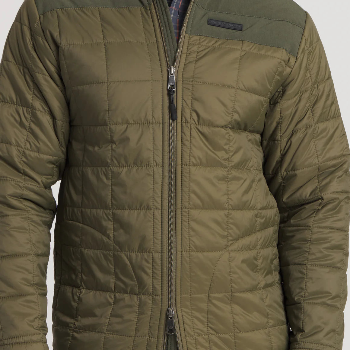 Olive green quilted jacket with zipper front and shoulder panel detail