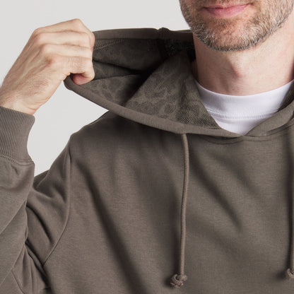 Close-up of man wearing olive green hoodie with drawstring and textured hood lining