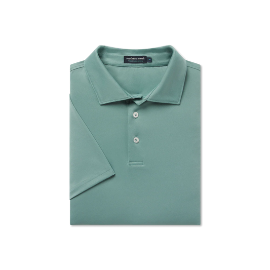 Folded green polo shirt with a brand label on a white background