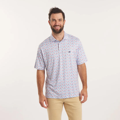 Man wearing a patterned polo shirt and beige pants on a white background