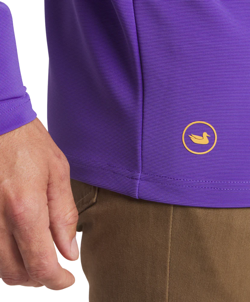 Purple performance quarter zip with yellow duck logo, worn with brown pants