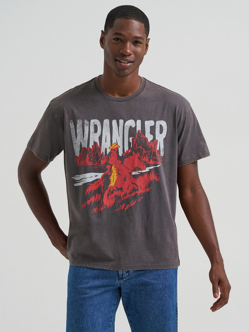 Man wearing a Wrangler t-shirt with a graphic design on a plain background