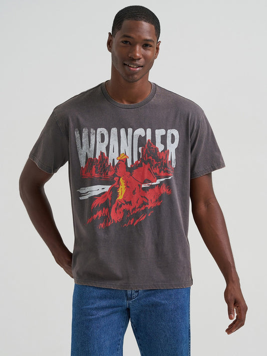 Man wearing a Wrangler t-shirt with a graphic design on a plain background