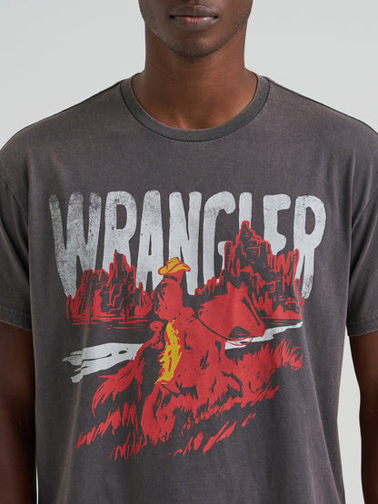Man wearing a Wrangler t-shirt with a graphic design on a plain background
