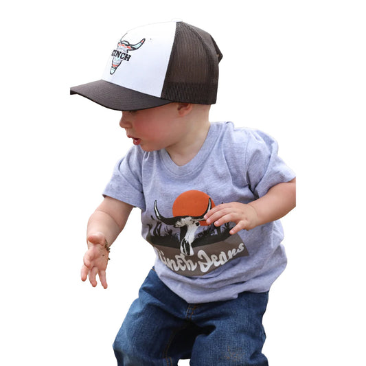 Child wearing a cap and t-shirt with a cow print on a white background
