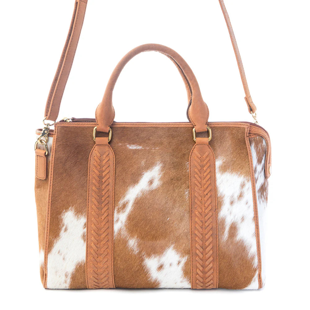 Brown and white cowhide handbag with tan leather handles and shoulder strap