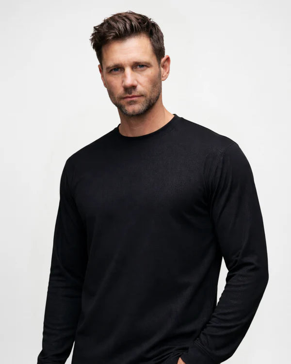 Man wearing a black long-sleeve shirt against a plain background