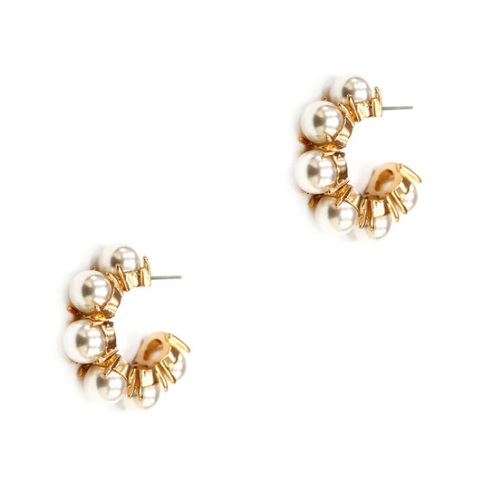 Pair of gold and pearl hoop earrings on a white background