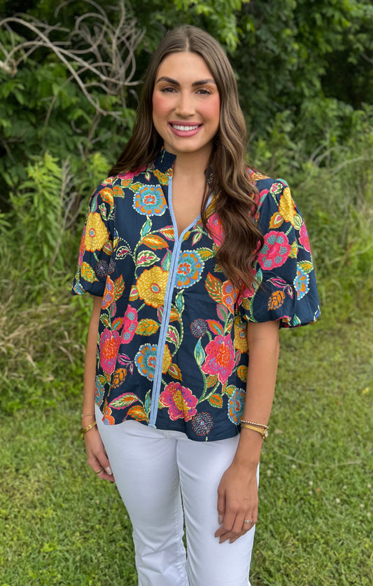 Woman wearing THML Puff sleeve print top with white jeans outside