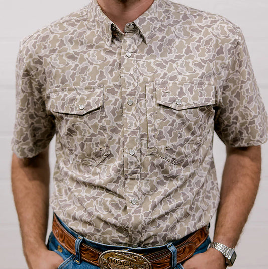 Person wearing a patterned shirt with a neutral background