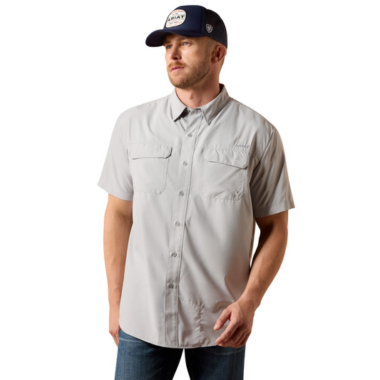 Man wearing a light gray button-up shirt and navy cap on a white background