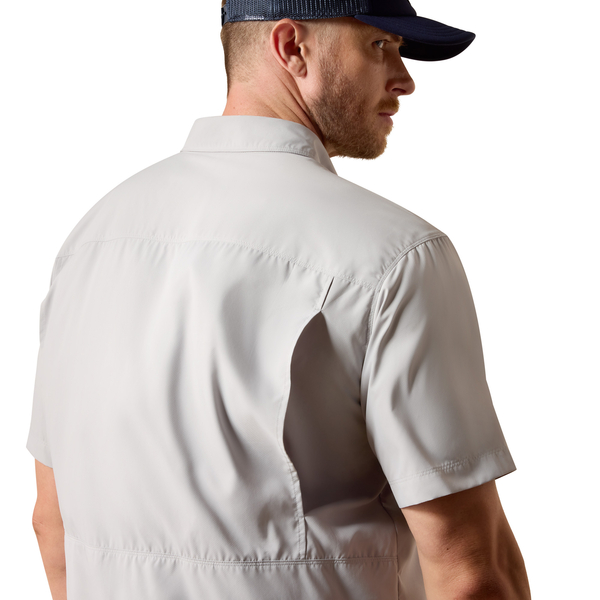 Man wearing a light gray short-sleeve shirt with a brand logo on a white background