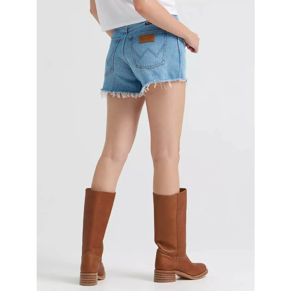 Person wearing denim shorts and brown knee-high boots on a white background