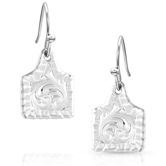 Silver earrings with intricate designs on a white background