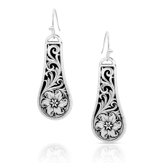 Pair of silver floral earrings on a white background