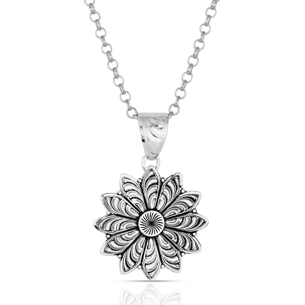 Silver necklace with a detailed floral pendant on a white background