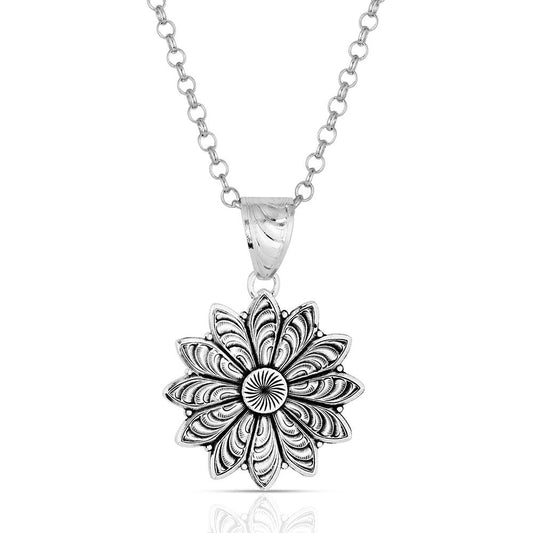 Silver necklace with a detailed floral pendant on a white background