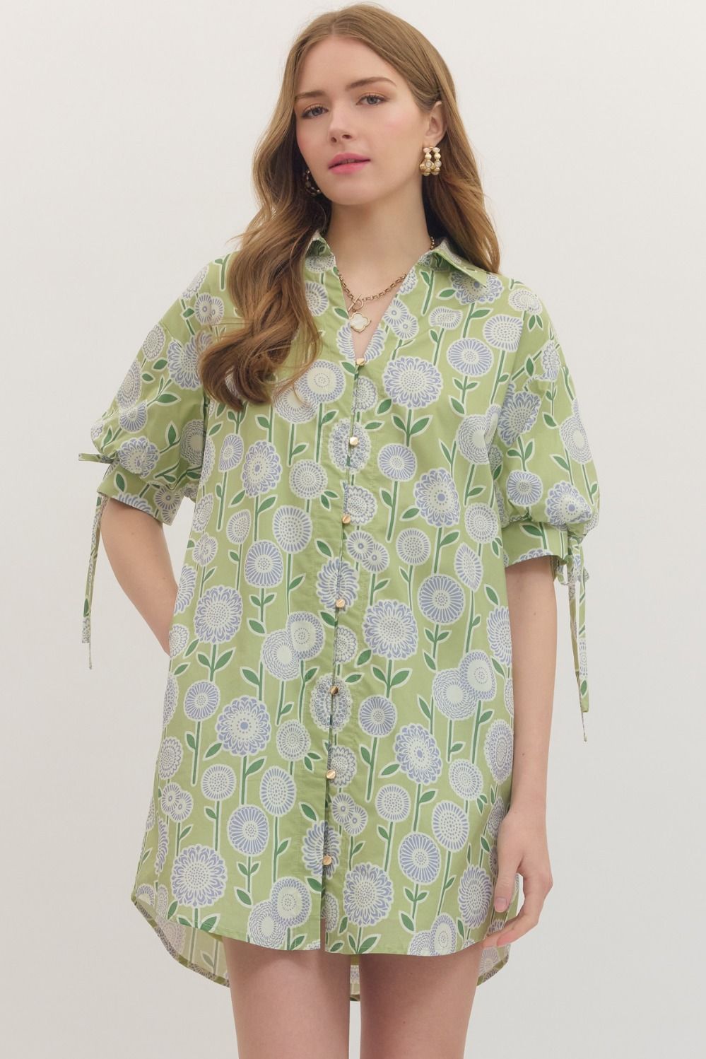 Woman wearing a green floral patterned dress against a white background