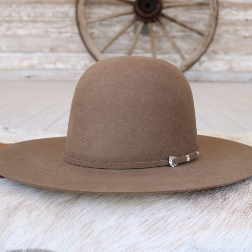 Wide brim brown felt cowboy hat with silver buckle detail, rustic western setting