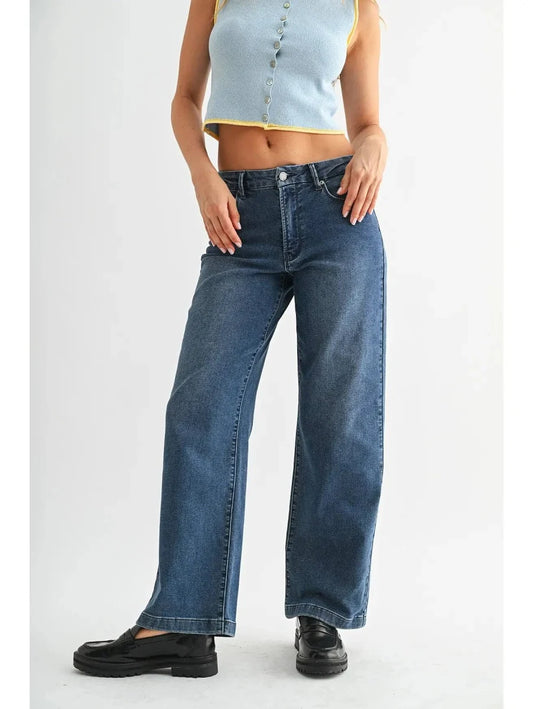 Woman in dark denim jeans and white background