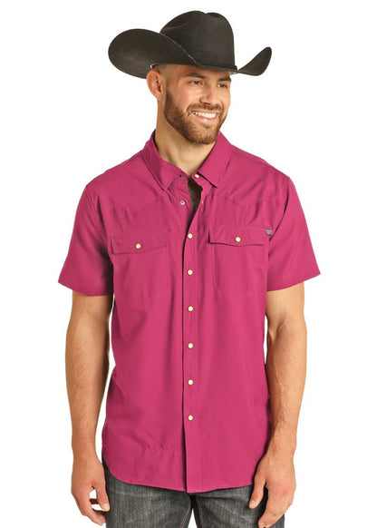 Man wearing a magenta short-sleeve shirt and black cowboy hat on a white background