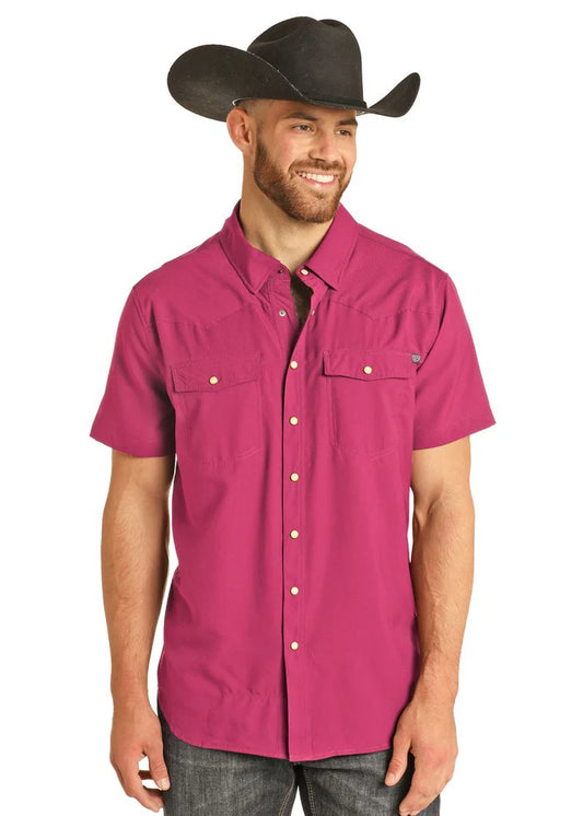Man wearing a magenta short-sleeve shirt and black cowboy hat on a white background