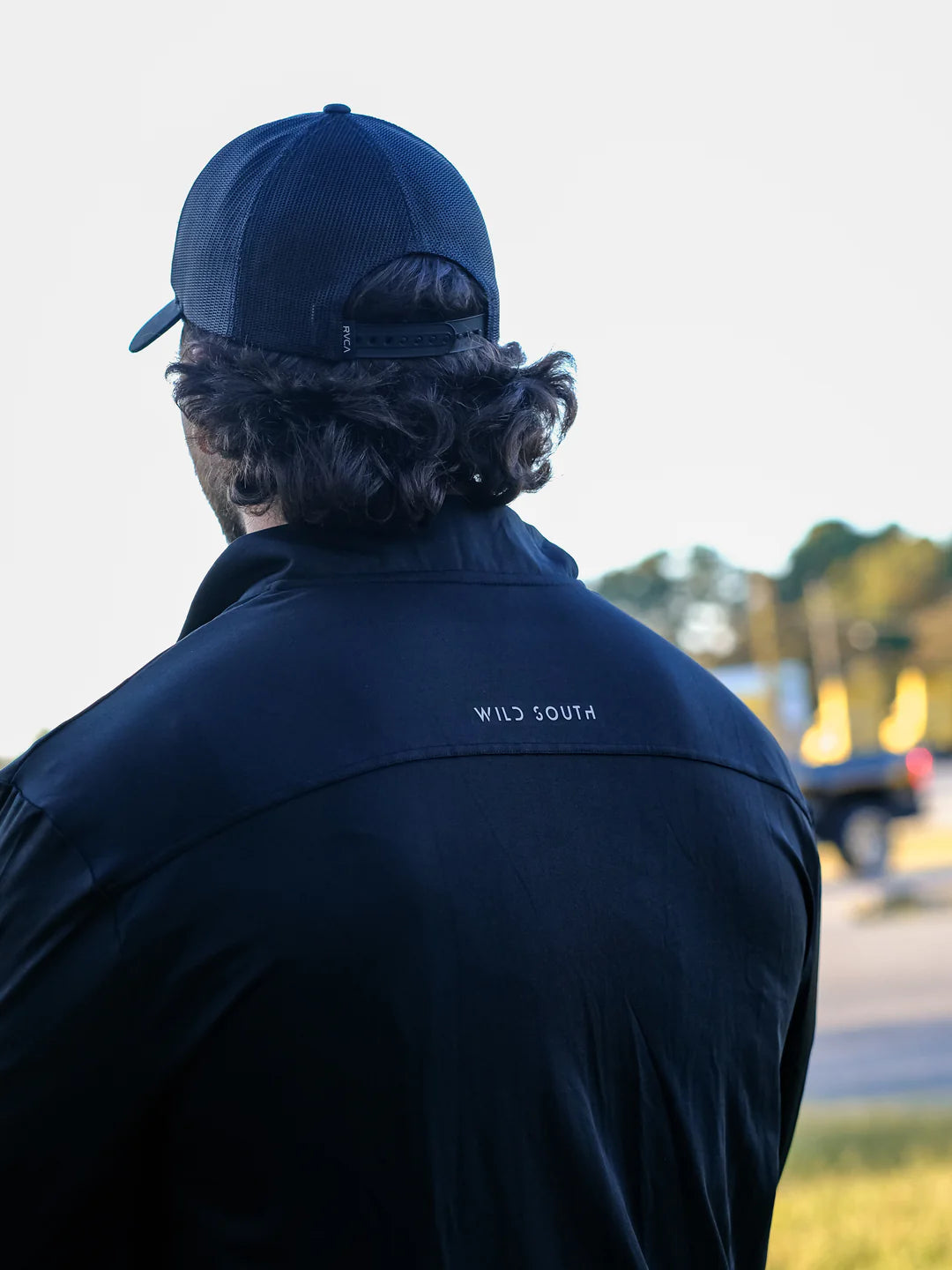 Person wearing a navy jacket with 'Wild South' branding, facing away from the camera.