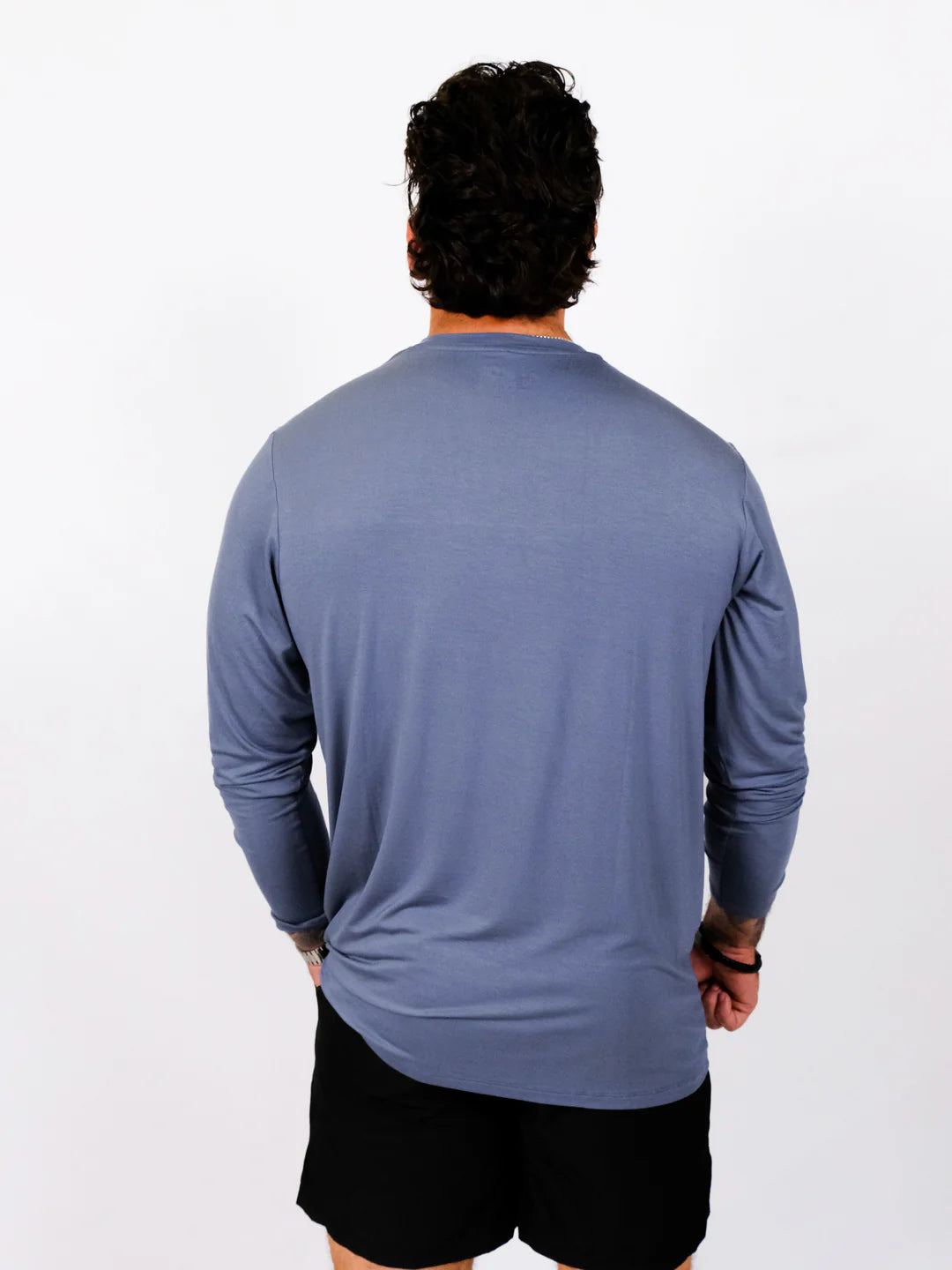 Person wearing a blue long-sleeve shirt on a white background