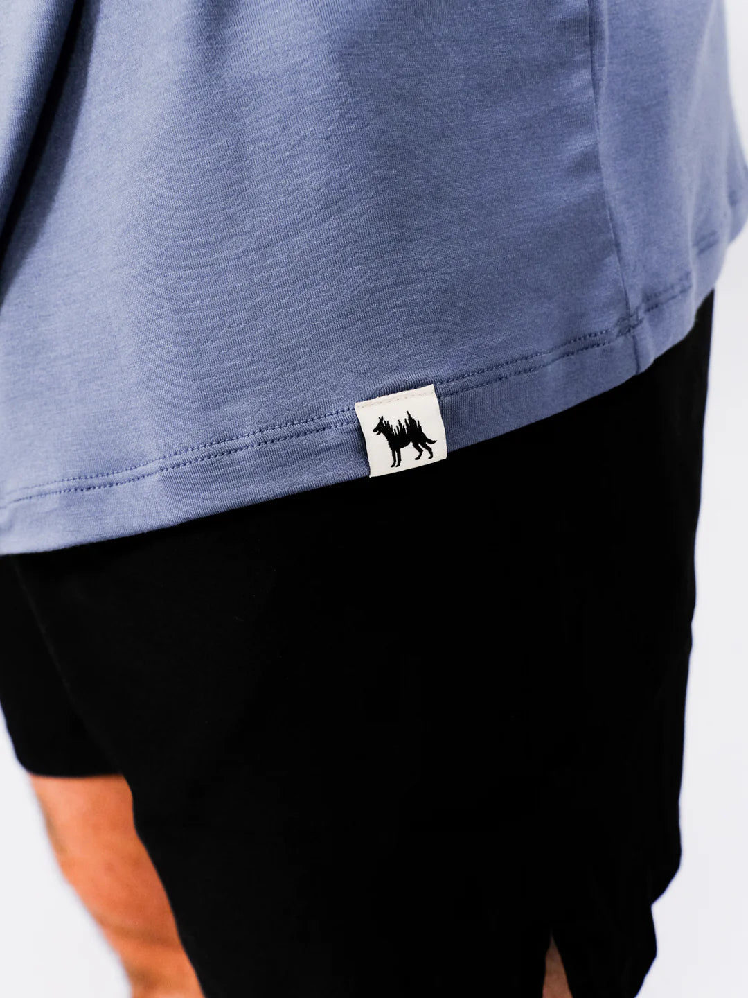 Close-up of a blue shirt with a brand logo on a white background