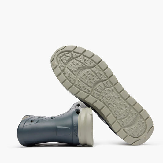 Close-up of a gray sandal with a textured sole on a white background